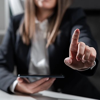 A woman holding a device pointing to someone