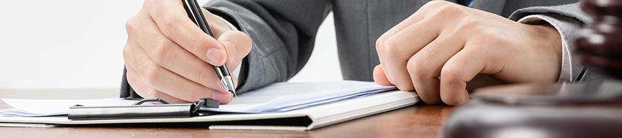 Writing legal documents on a desk about penalty for not having a registered agent