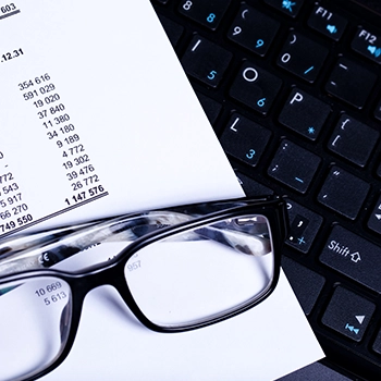 List of taxes to pay with eyeglasses on top of document and laptop