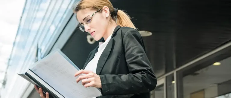 Woman reading Maryland LLC Taxes document outdoors