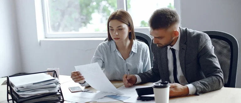 Two business people talking about the LLC taxes in North Dakota