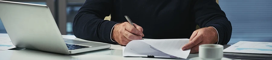 A man reading some documents about state LLC taxes in North Carolina