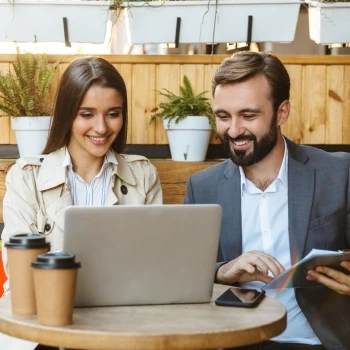 Two people having a conversation in front of a laptop