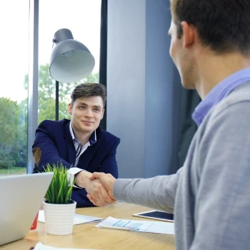 Two people shaking hands in an office