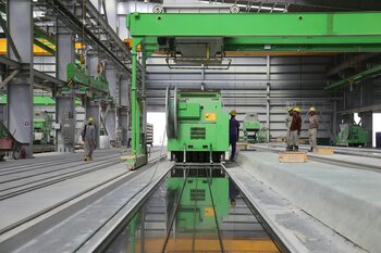 People standing near a green metal industrial machine 