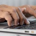 A man looking up an LLC in Alabama on laptop