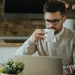 A business man browsing for Alaska's best registered agent services while drinking coffee