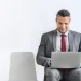 A business man sitting while looking up an LLC in Texas using a laptop