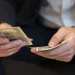 A sitting business man while counting money for an LLC in Colorado