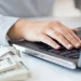 A business woman working on her laptop as she search for LLC cost in Maine